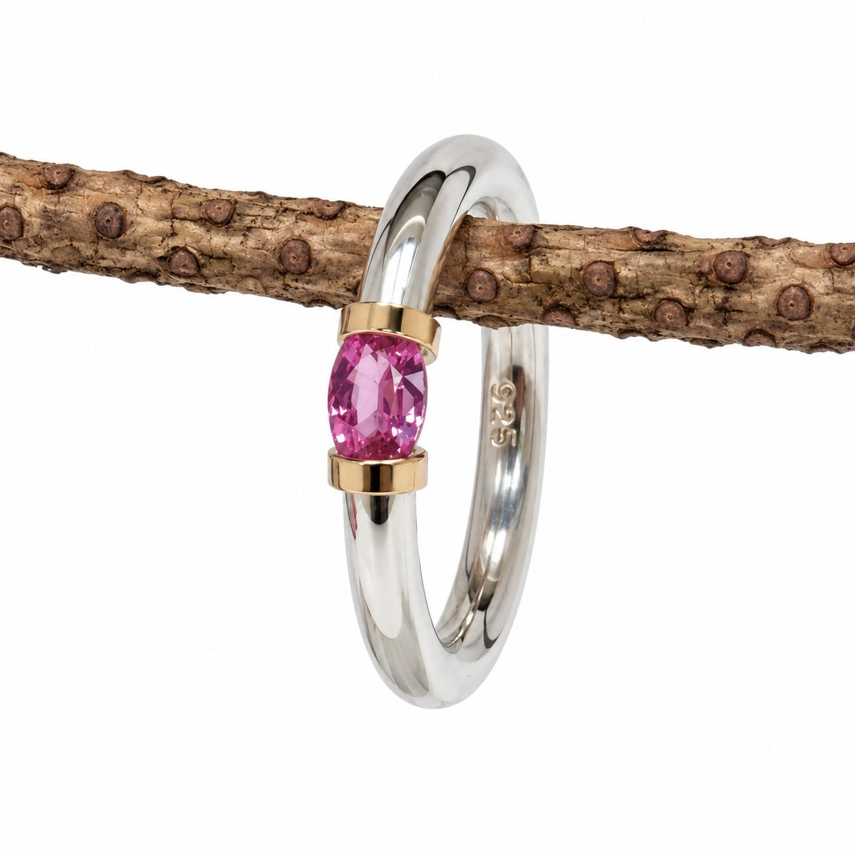 A Sterling Silver Pink Sapphire Tension Set Ring With Gold Detail