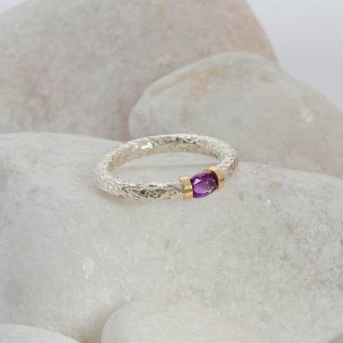 An Amethyst hand textured silver ring with a gold detail