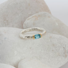 Load image into Gallery viewer, A Swiss Blue Topaz ring in a hand textured silver and gold band
