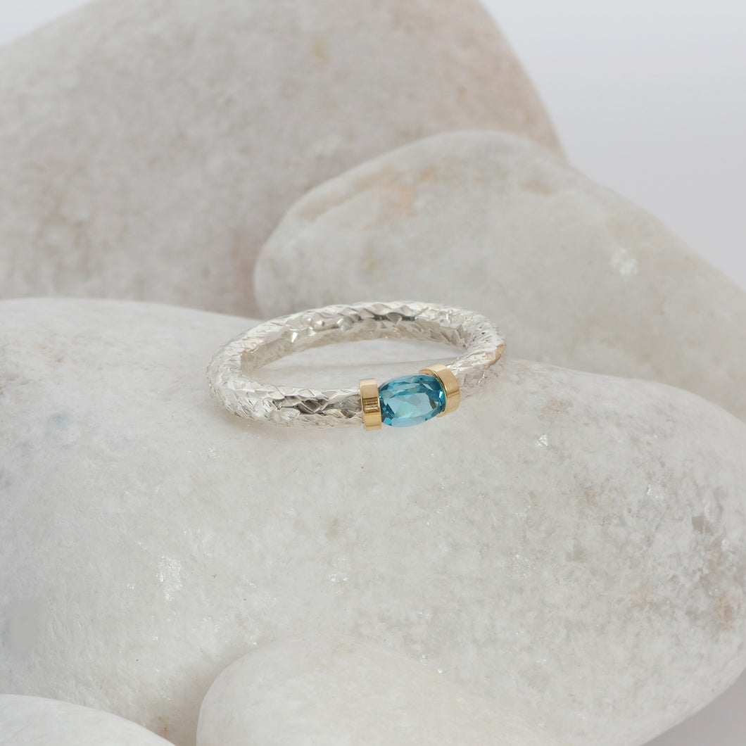 A Swiss Blue Topaz ring in a hand textured silver and gold band