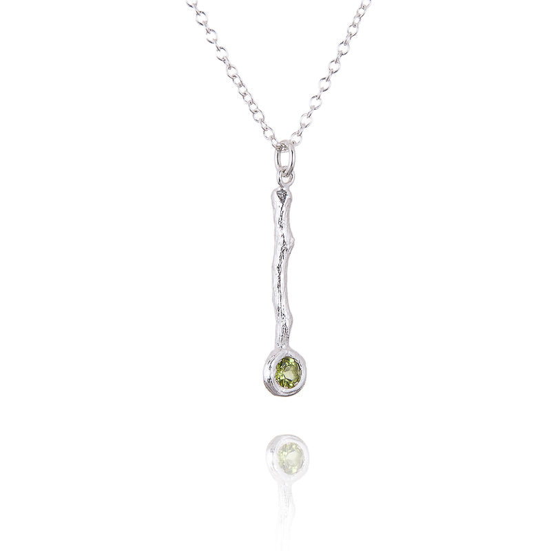 A twig pendant in silver with a peridot