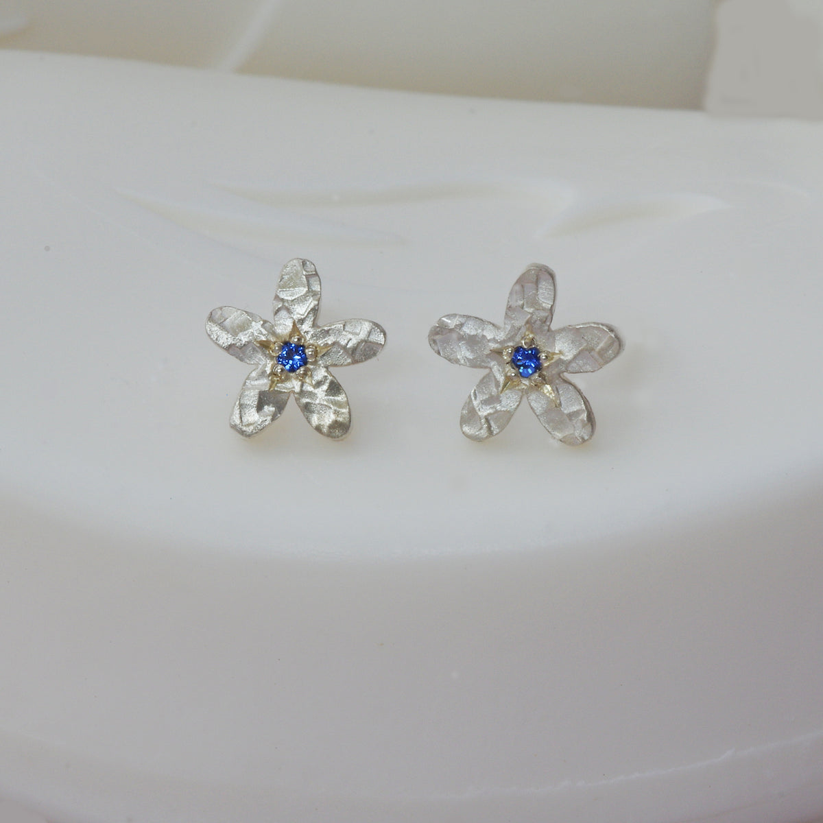 Sapphire set into a silver flower ear stud